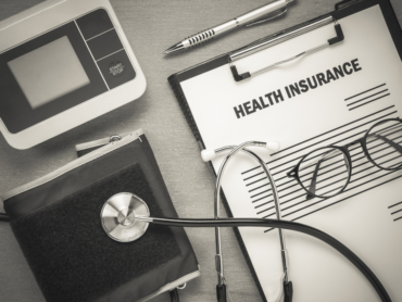 top-view-health-insurance-form-eyeglasses-pulse-gauge-with-stethoscope-wooden-background